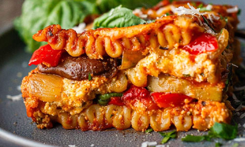 A freshly baked slice of Roasted Vegetable Lasagna with golden cheese