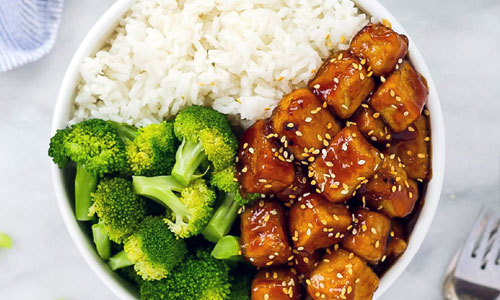 Crispy cubes of Sesame Tofu covered in a shiny glaze